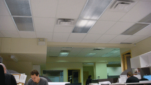 Typical office lighting fixture installation in suspended ceiling grid.